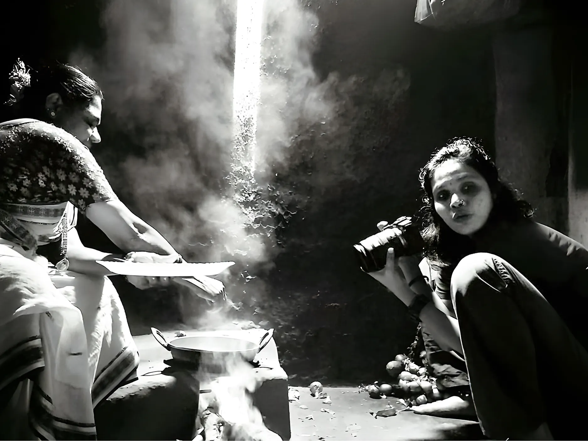 Ženska s fotoaparatom, ki fotografira drugo, ki kuha